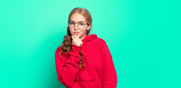 Mujer bonita rubia que parece seria, confundida, insegura y pensativa, dudando entre opciones o elecciones