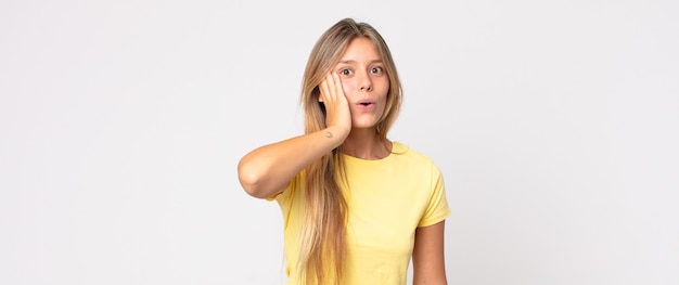 Mujer bonita rubia que se siente aburrida, frustrada y con sueño después de una tarea tediosa, aburrida y tediosa, sosteniendo la cara con la mano