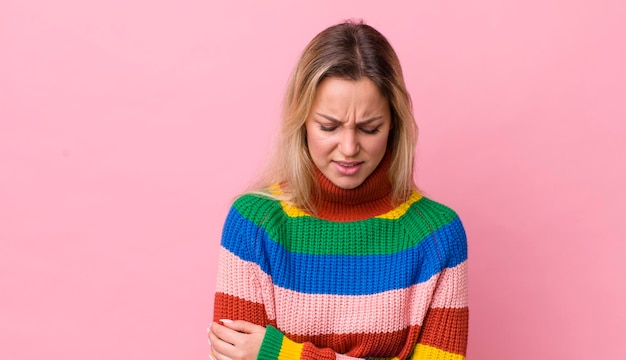 Mujer bonita rubia que se siente ansiosa, enferma, enferma e infeliz que sufre un dolor de estómago o gripe