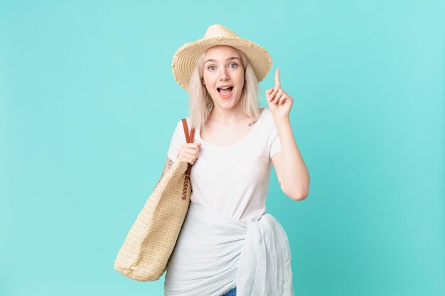 Mujer bonita rubia que se siente como un genio feliz y emocionado después de realizar una idea. concepto de verano