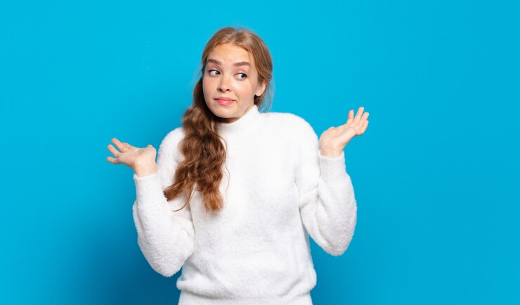 Foto mujer bonita rubia que se siente desconcertada y confundida, dudando, ponderando o eligiendo diferentes opciones con expresión divertida