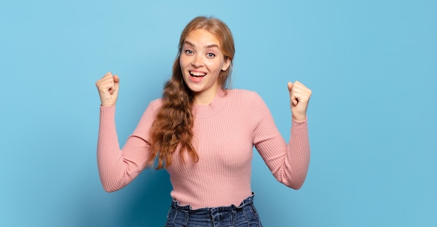 Mujer bonita rubia que se siente feliz, positiva y exitosa, celebrando la victoria, los logros o la buena suerte