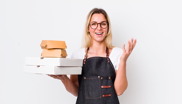 Mujer bonita rubia que se siente feliz sorprendida al darse cuenta de una solución o idea para llevar el concepto de comida rápida