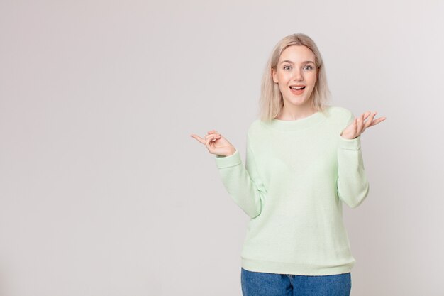 Mujer bonita rubia que se siente feliz, sorprendida al darse cuenta de una solución o idea