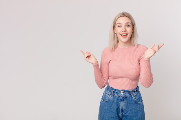 Mujer bonita rubia que se siente feliz, sorprendida al darse cuenta de una solución o idea