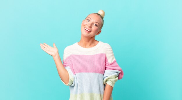 Mujer bonita rubia que se siente feliz, sorprendida al darse cuenta de una solución o idea