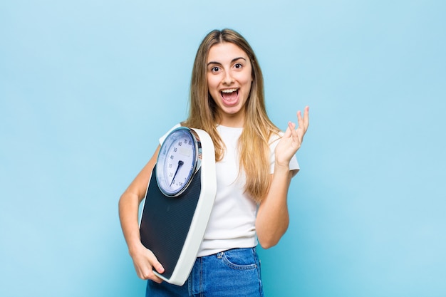 Mujer bonita rubia que se siente feliz, sorprendida y alegre, sonriendo con actitud positiva, dándose cuenta de una solución o idea