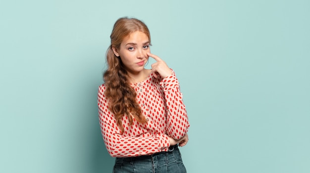 Mujer bonita rubia que te vigila, no confía, mira y permanece alerta y vigilante