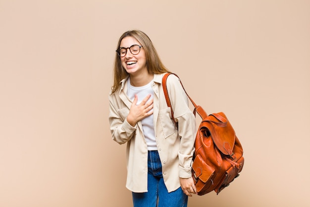 Mujer bonita rubia riendo a carcajadas de una broma hilarante, sintiéndose feliz y alegre, divirtiéndose