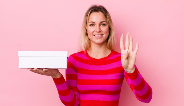 Mujer bonita rubia sonriendo y luciendo amigable mostrando el concepto de caja blanca número cuatro