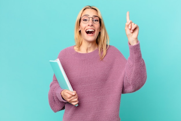 Mujer bonita rubia sosteniendo libros. concepto de estudiante