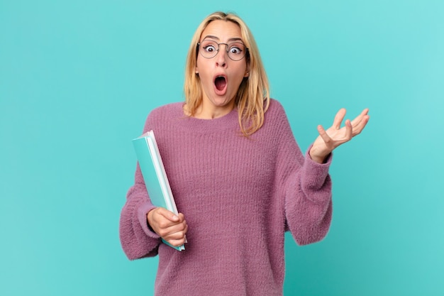 Mujer bonita rubia sosteniendo libros. concepto de estudiante