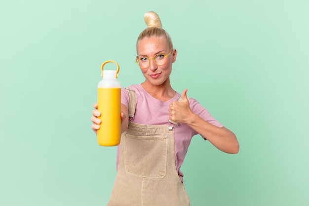 Mujer bonita rubia con un termo de café