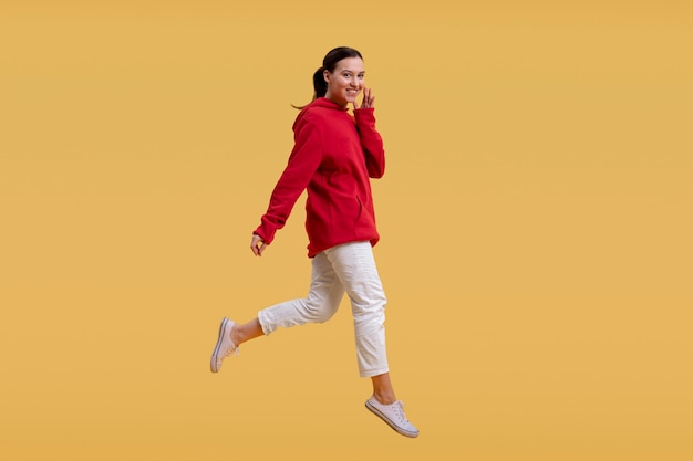 Foto mujer bonita saltando aislado en naranja