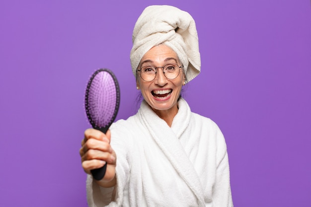 Mujer bonita senior con un cepillo de pelo