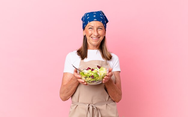 Mujer bonita senior preparando una ensalada