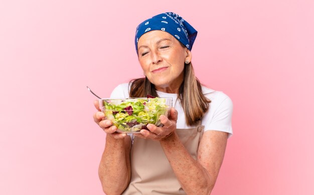 Mujer bonita senior preparando una ensalada