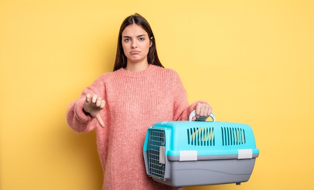 Mujer bonita sintiéndose mostrando los pulgares hacia abajo concepto de portador de mascotas