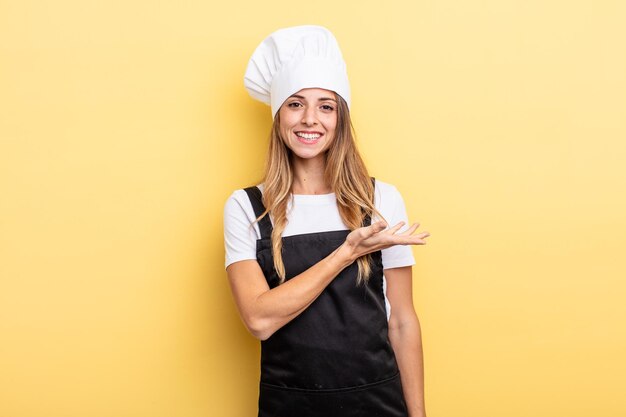 mujer bonita sonriendo alegremente, sintiéndose feliz y mostrando un concepto. concepto de cocinero