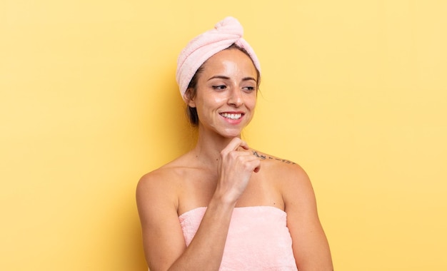 mujer bonita sonriendo con una expresión feliz y segura con la mano en la barbilla. concepto de ducha y belleza