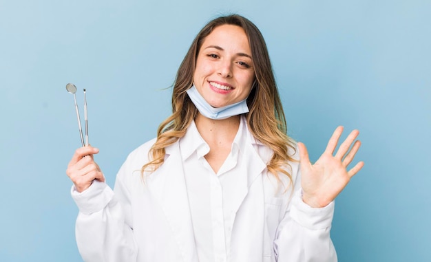 Mujer bonita sonriendo felizmente saludando con la mano y dándote la bienvenida