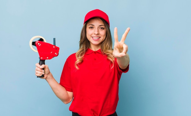 Foto mujer bonita sonriendo y luciendo feliz gesticulando victoria o paz