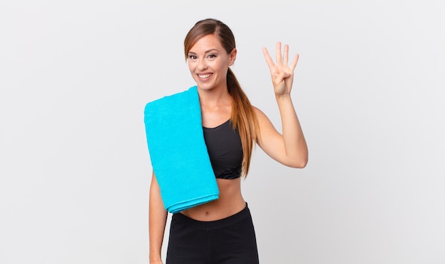 Mujer bonita sonriendo y mirando amigable, mostrando el número cuatro. concepto de fitness