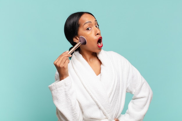 Mujer bonita sorprendida haciendo su maquillaje