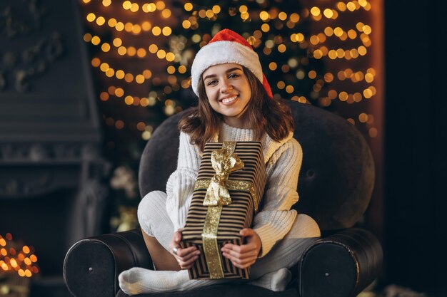 Mujer bonita con un suéter cálido, calcetines y gorro de Navidad