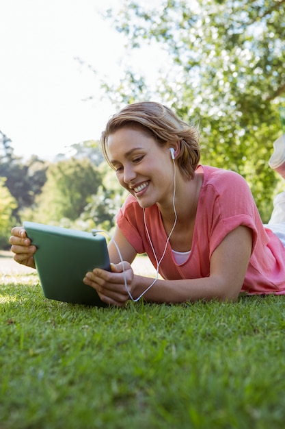 Mujer bonita con tableta en el parque