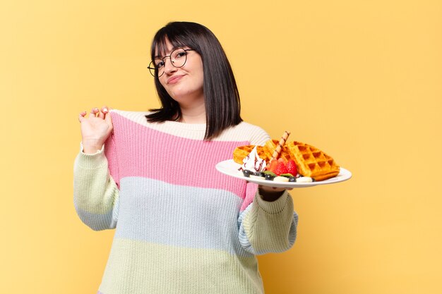 Mujer bonita de talla grande comiendo gofres