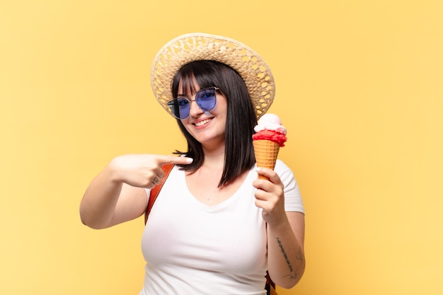 Mujer bonita de talla grande con gafas de sol, helado y un sombrero de vacaciones