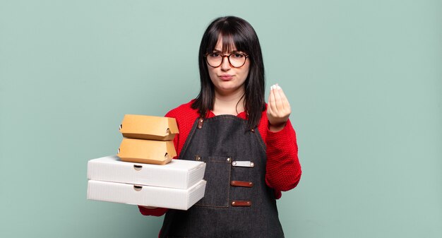 ¡Mujer bonita de talla grande que hace un gesto de capice o dinero, diciéndote que pagues tus deudas!