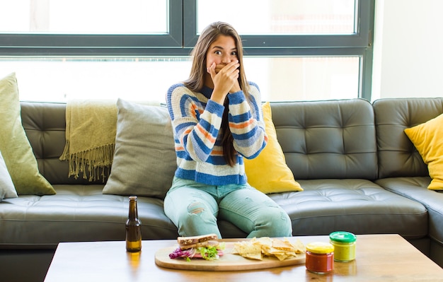 Mujer bonita tapándose la boca con las manos con una expresión de sorpresa y sorpresa, manteniendo un secreto o diciendo ¡Uy