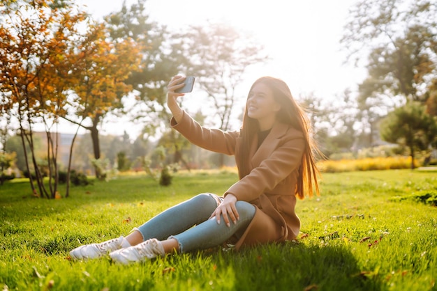 Foto mujer bonita con teléfono inteligente pasando un buen rato en el fin de semana de otoño concepto de estilo de vida de la gente