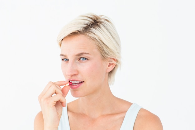 Mujer bonita tomando pastillas