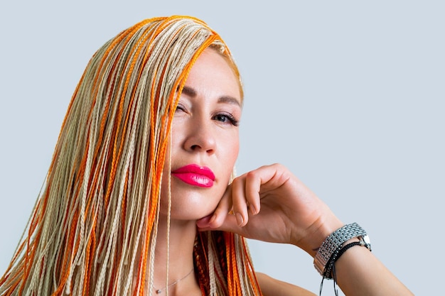 Mujer bonita con trenzas de cabello naranja colorido Concepto de salón de peluquería Trenzas de niña Retrato de una hermosa joven con trenzas Hermosa mujer elegante con kanekalon colorido trenzado en el cabello