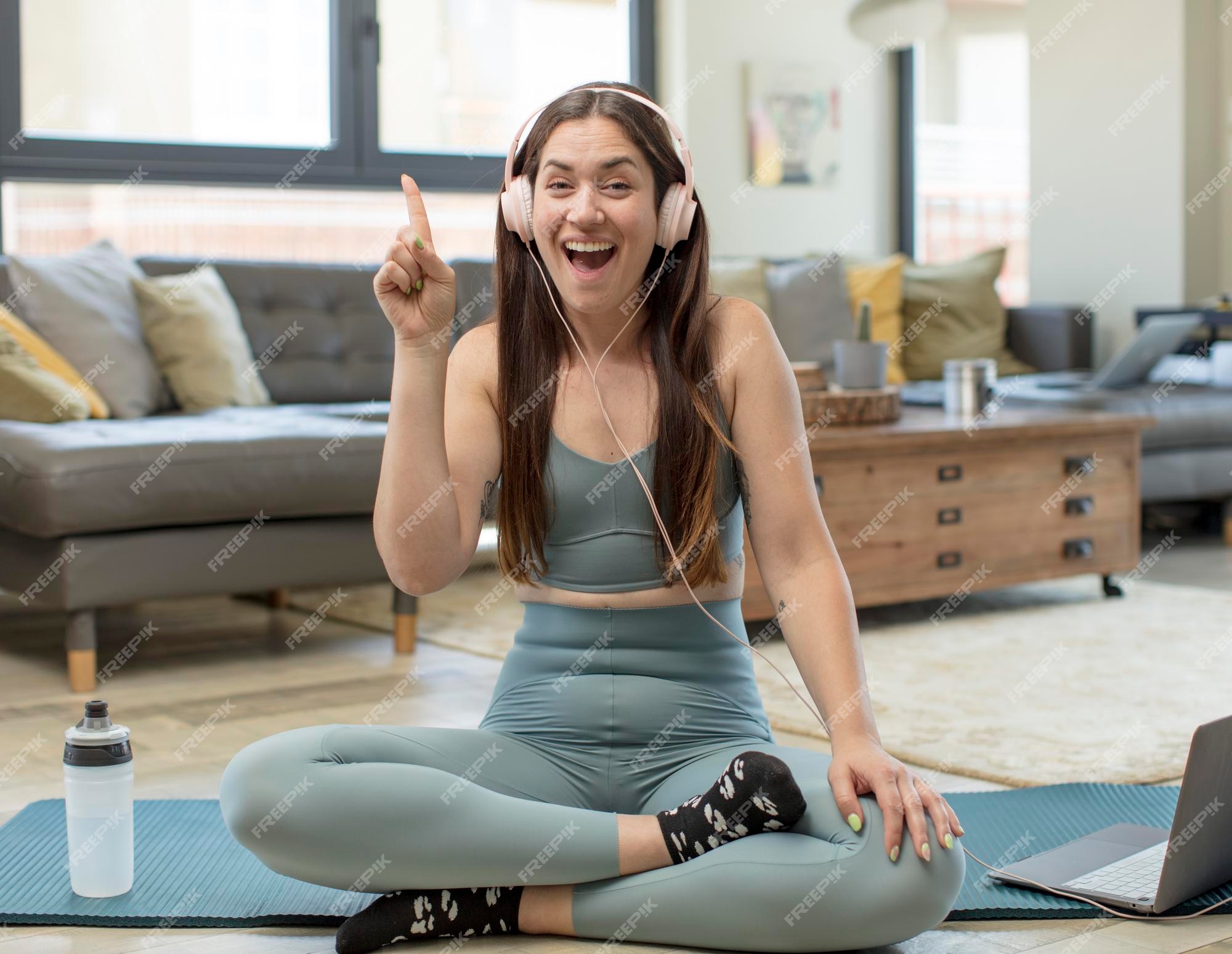 Mujer bonita vistiendo ropa deportiva y haciendo yoga.