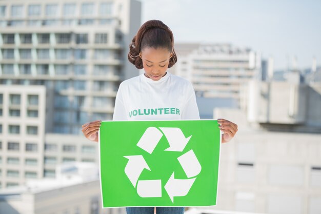 Mujer bonita voluntaria con cartel de reciclaje