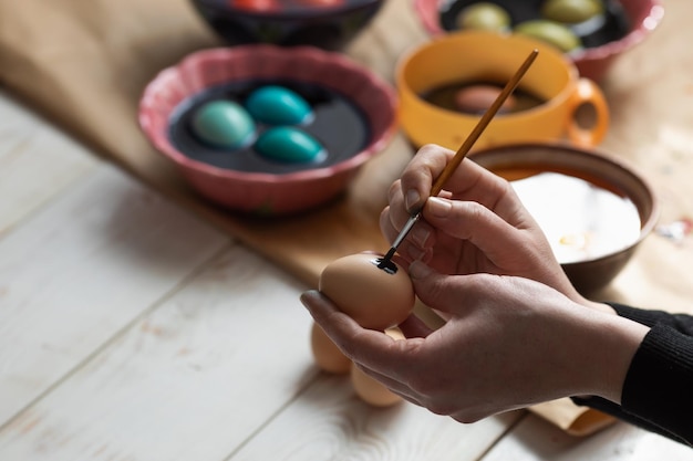 Una mujer con una borla pinta un huevo de Pascua Preparándose para la Pascua