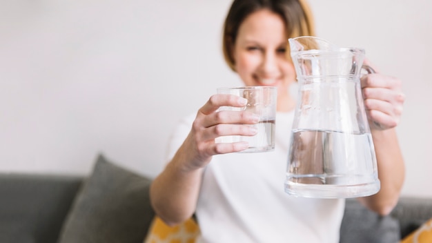 Mujer borrosa mostrando agua