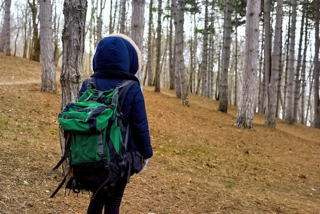 Mujer en un bosque de finales de invierno con mochila