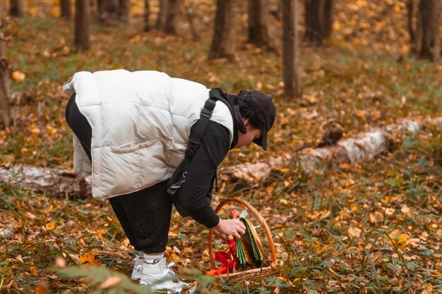 Foto mujer en el bosque de otoño en busca de setas