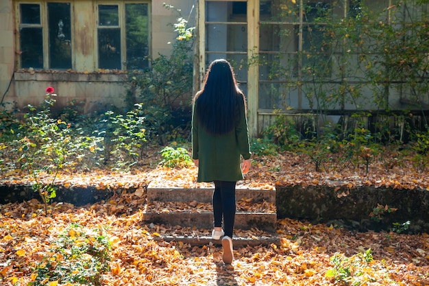 Foto mujer en el bosque de otoño con casa