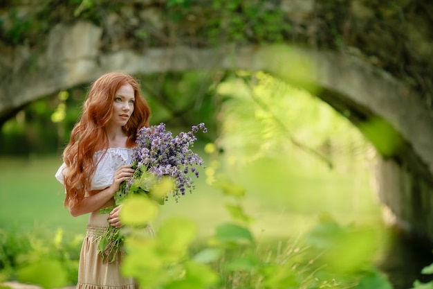 Mujer en el bosque con un ramo de flores