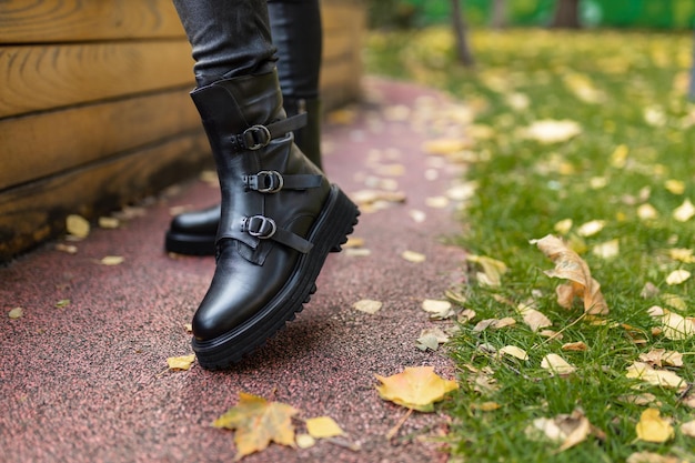 Una mujer con botas negras con hebillas y una bota negra con hebillas.