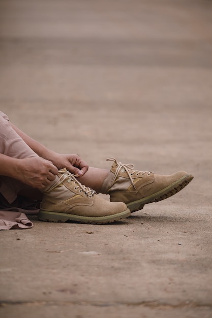 Mujer con botas sentado en la carretera local.