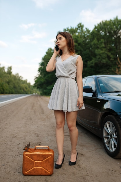 Mujer con bote de gasolina en la carretera