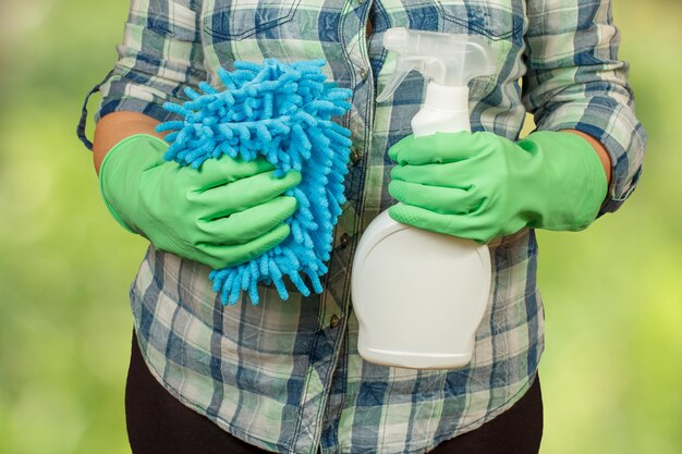 Mujer con una botella de detergente y un trapo