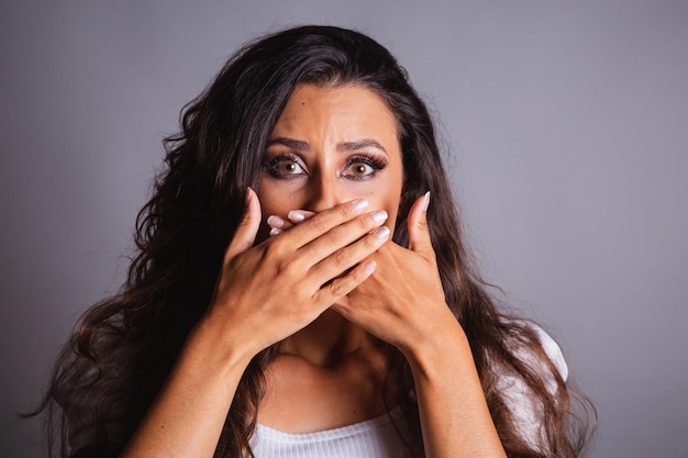 Mujer brasileña cabello castaño asustada violencia doméstica lucha contra el feminicidio Manos sobre la boca silencio